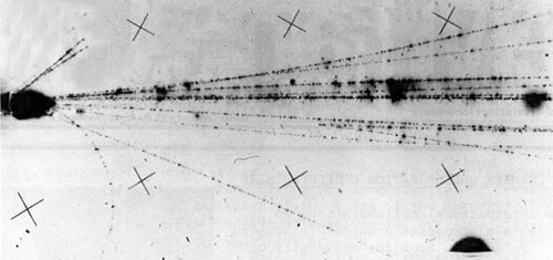 Photo of an event in the streamer chamber triggered by two muons, illustrating the Vee of a neutral strange particle decay. E-416 (.completed in July, 1975) was searching for correlations of dimuons with neutral strange particles in pi minus interactions
